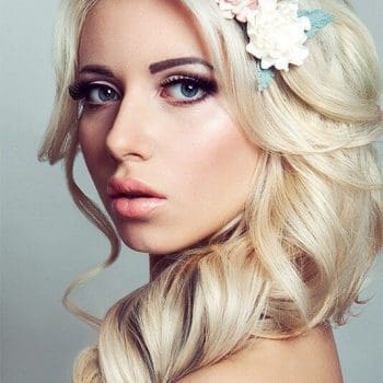 Coiffure pour jeune fille blonde avec fleurs blanches et rouges