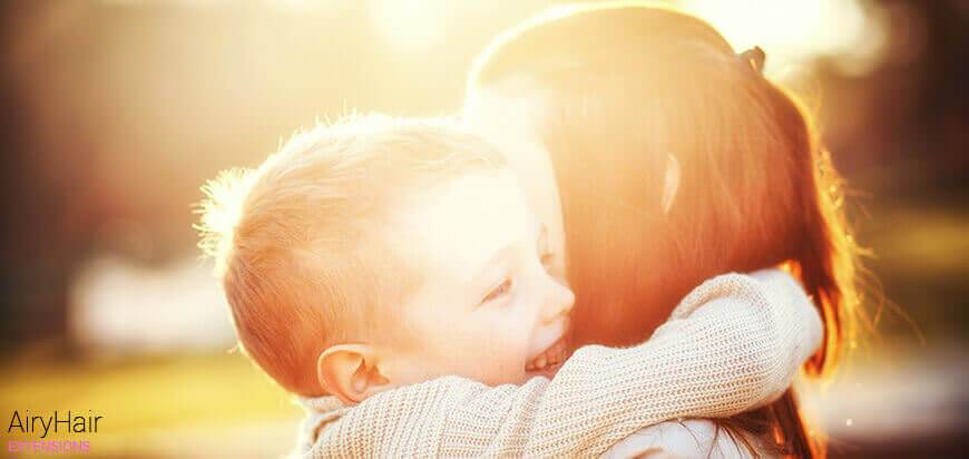 A happy kid and his mother smiling